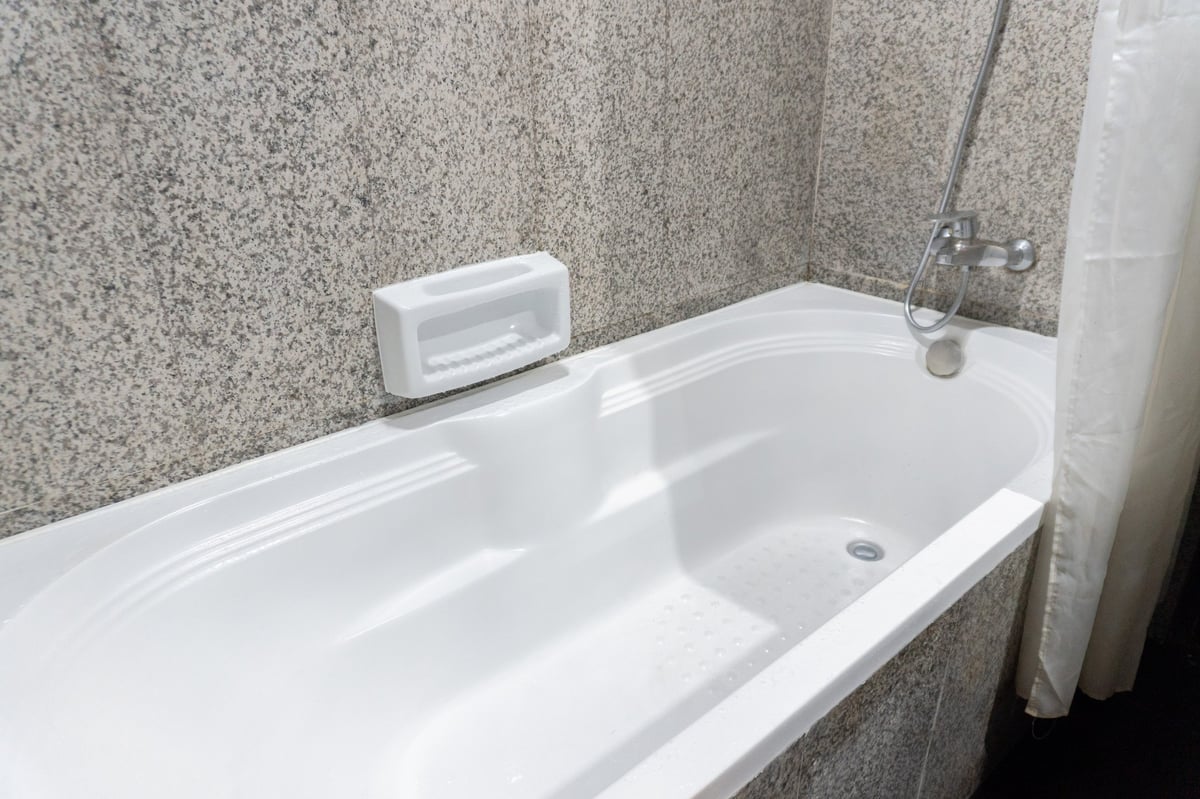 Clean white bathtub in a minimalist bathroom after resurfacing